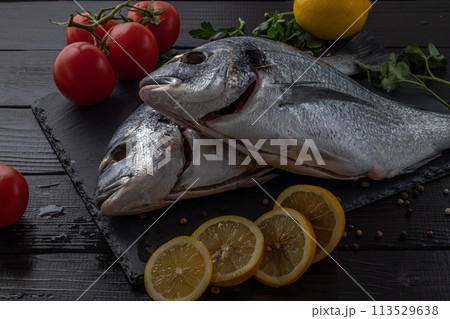 Sea bream or dorado sea fish herbs on dark slate background Top view  113529638