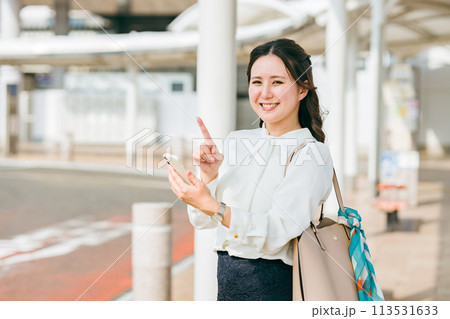 駅・ステーションのロータリーでスマホを使う女性（アプリ・モバイルチケット・チケットレス・電子乗車券） 113531633