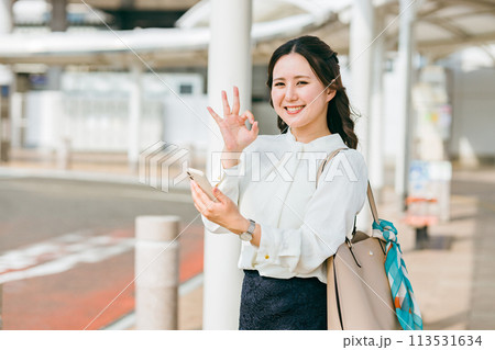 駅・ステーションのロータリーでスマホを使う女性(アプリ・モバイルチケット・チケットレス・電子乗車券) 駅・ステーションのロータリーでスマホを使う女性(アプリ・モバイルチケット・チケットレス・電子乗車券) 113531634