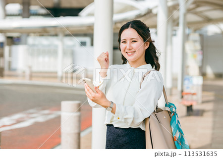 駅・ステーションのロータリーでスマホを使う女性(アプリ・モバイルチケット・チケットレス・電子乗車券) 駅・ステーションのロータリーでスマホを使う女性(アプリ・モバイルチケット・チケットレス・電子乗車券) 113531635