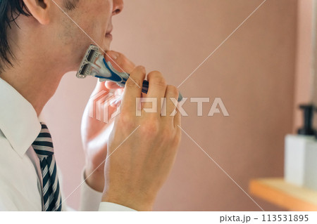朝出勤前に洗面所で髭剃りをするスーツ姿の若いアジア人ビジネスマン 113531895
