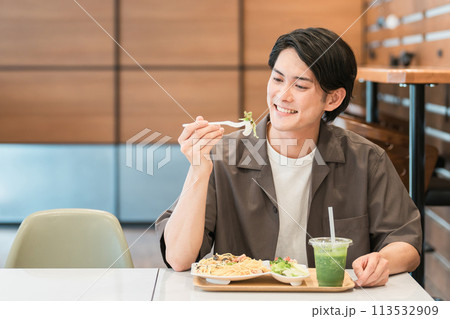 カフェでランチ・パスタを食べる若いアジア人男性 カフェでランチ・パスタを食べる若いアジア人男性 113532909