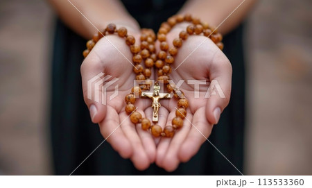 Soulful prayer: a man in quiet devotion, hands clasped around a rosary cross, seeking solace and spiritual connection, capturing the essence of serene contemplation, faith, and religious devotion. 113533360