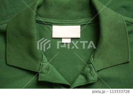 Blank white laundry care clothes label on green shirt fabric texture background 113533726