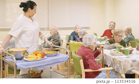 Cook entering with food to the dining room of geriatric Cook entering with food to the dining room of geriatric 113534516