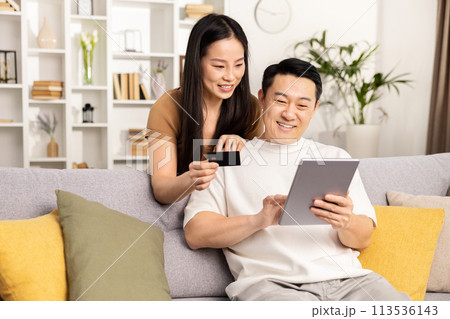 Couple Shopping Online Together On Tablet At Home 113536143