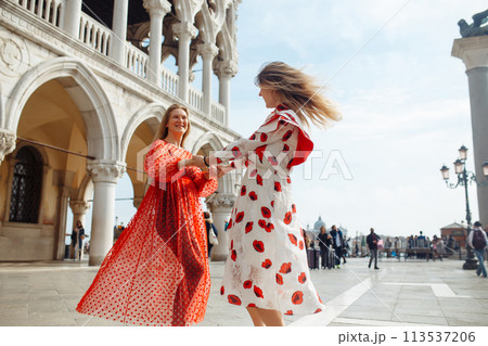 Mom and daughter in fashionable dresses walk around Venice. Lifestyle, travel, tourism. Mom and daughter in fashionable dresses walk around Venice. Lifestyle, travel, tourism. 113537206