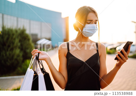 Beautiful woman with telephone enjoying shopping near shopping center. Black friday, sale concept. Covid- 2019. Beautiful woman with telephone enjoying shopping near shopping center. Black friday, sale concept. Covid- 2019. 113538988