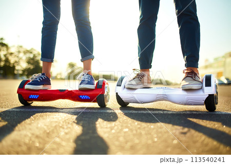 Young man and woman riding on the Hoverboard in the park. content technologies. a new movement. 113540241