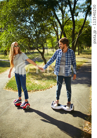 Young man and woman riding on the Hoverboard in the park. content technologies. a new movement. 113540250