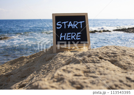 Start Here symbol. Concept word Start Here on black chalk background. Beautiful sea background. Business and Start Here concept. Copy space 113543395