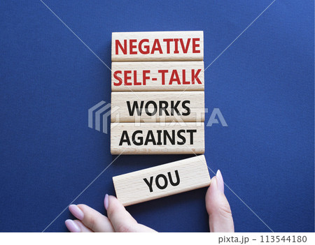 Negative self-talk works against you symbol. Concept words Negative self-talk works against you on wooden blocks. Beautiful deep blue background. Businessman hand. Psychological concept. Copy space 113544180