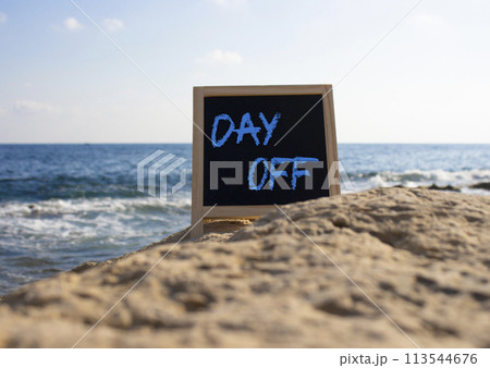 Day off symbol. Day off black chalk blackboard. Beautiful sea background. Business and Day off concept. Copy space. 113544676