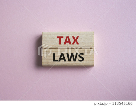 Tax Laws symbol. Concept word Tax Laws on wooden blocks. Beautiful pink background. Business and Tax Laws concept. Copy space 113545166