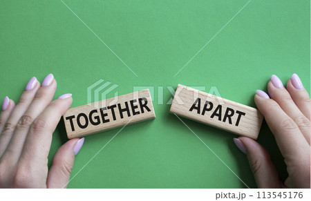 Together or Apart symbol. Concept word Together or Apart on wooden blocks. Businessman hand. Beautiful green background. Business and Together or Apart concept. Copy space Together or Apart symbol. Concept word Together or Apart on wooden blocks. Businessman hand. Beautiful green background. Business and Together or Apart concept. Copy space 113545176