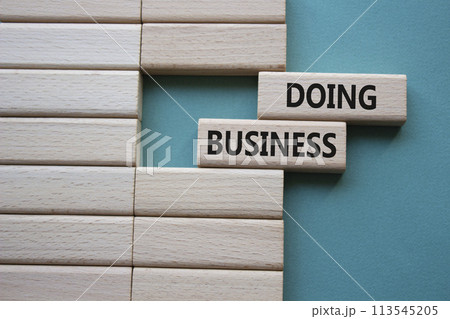 Doing Business symbol. Concept word Doing Business on wooden blocks. Beautiful grey green background. Business and Doing Business concept. Copy space Doing Business symbol. Concept word Doing Business on wooden blocks. Beautiful grey green background. Business and Doing Business concept. Copy space 113545205