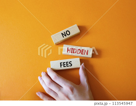 No hidden fees symbol. Concept word No hidden fees on wooden blocks. Businessman hand. Beautiful orange background. Business and No hidden fees concept. Copy space 113545947