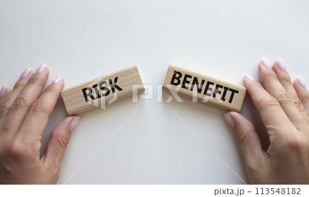 Risk or Benefit symbol. Concept word Risk or Benefit on wooden blocks. Businessman hand. Beautiful white background. Business and Risk or Benefit concept. Copy space 113548182
