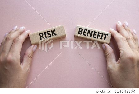 Risk or Benefit symbol. Concept word Risk or Benefit on wooden blocks. Businessman hand. Beautiful pink background. Business and Risk or Benefit concept. Copy space 113548574