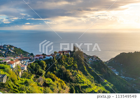 Taditional Madeiran houses in Funchal behind a banana plantation and ocean sunset. Taditional Madeiran houses in Funchal behind a banana plantation and ocean sunset. 113549549