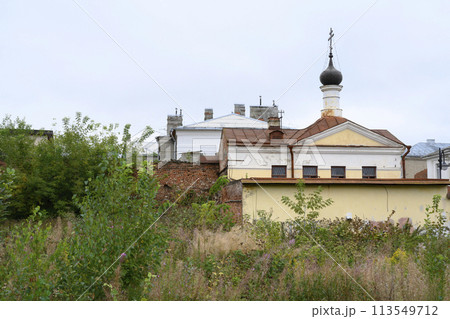 A wasteland overgrown with grass, a brick wall and an old church in Rybinsk, Russia A wasteland overgrown with grass, a brick wall and an old church in Rybinsk, Russia 113549712