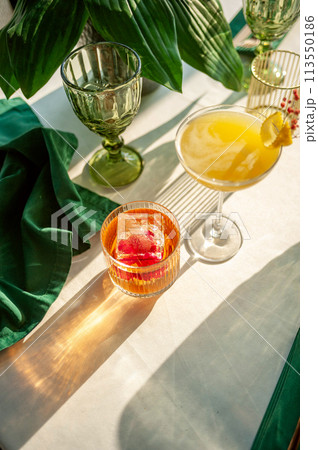 Two refreshing summer cocktails with lemon, mint, cranberry on a table 113550186