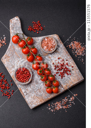 A sprig of ripe red cherry tomatoes as an ingredient for cooking at home A sprig of ripe red cherry tomatoes as an ingredient for cooking at home 113551576