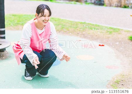 公園の遊具の前で子供と遊ぶ保育士 113551676