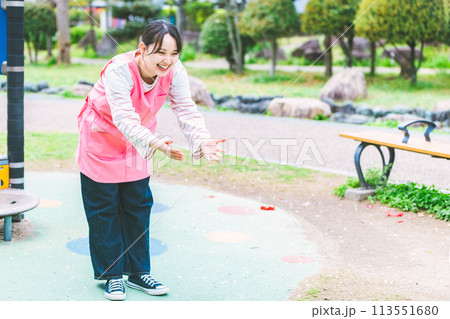 公園の遊具の前で子供と遊ぶ保育士 113551680