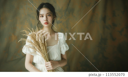 稲穂を持ったカメラ目線の若い女性 稲穂を持ったカメラ目線の若い女性 113552070