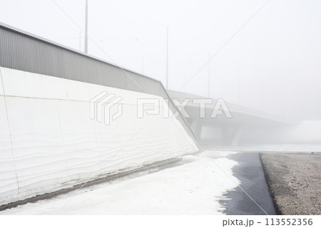 concrete bridge in heavy fog in early spring 113552356