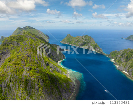 Tapiutan Island and Matinloc Island with boa over blue sea. El Nido, Palawan. Philippines. 113553481