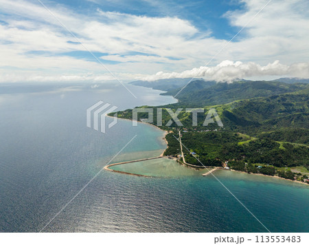 Aerial view of San Agustin with turquoise sea water and coral reefs. Tablas Island. Romblon, Philippines. Aerial view of San Agustin with turquoise sea water and coral reefs. Tablas Island. Romblon, Philippines. 113553483