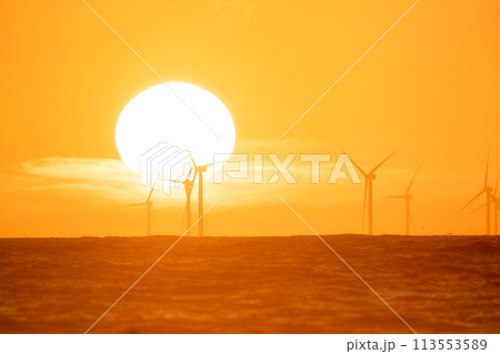 Wind turbine on the sea during sunset. Renewable energy sources. Technology and production. Wind turbine on the sea during sunset. Renewable energy sources. Technology and production. 113553589