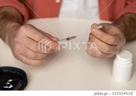 Unknown diabetic man with syringe preparing for insulin injection 113554519