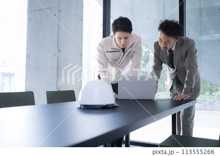 施工図を確認する現場監督と施工管理技士　ビルの設計や施工管理などのイメージ 考える悩むビジネスマン 113555266