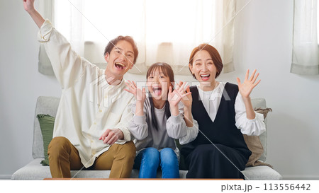 リビングルームでテレビを見ながら喜ぶ親子 113556442