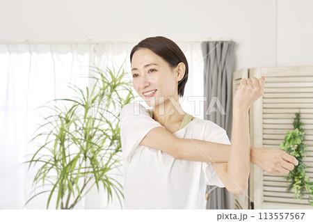 自宅で腕のストレッチをする40代の女性 113557567
