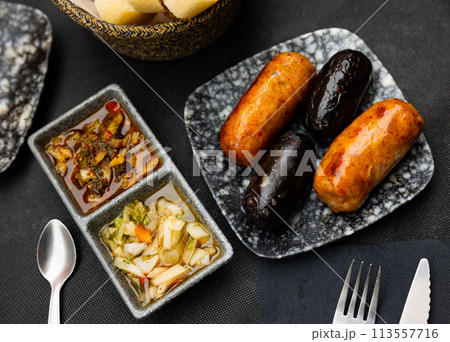 Grilled creole sausages served with pickled vegetables Grilled creole sausages served with pickled vegetables 113557716
