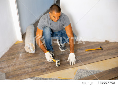 Man laying parquet on floor 113557758