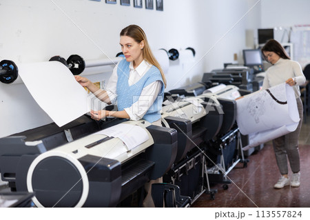 Woman working in printing office, using printer 113557824