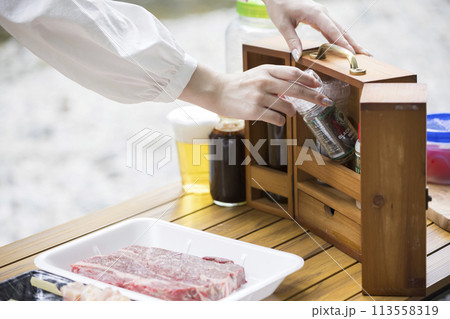 バーベキューイメージ 調味料入れから調味料を取り出す女性手元 バーベキューイメージ 調味料入れから調味料を取り出す女性手元 113558319