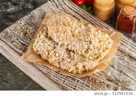 Breaded raw breaded meat schnitzel 113561316