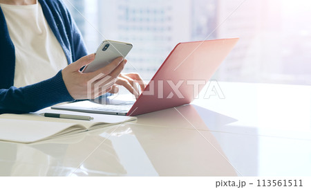 ノートパソコンとスマホを使う女性 113561511