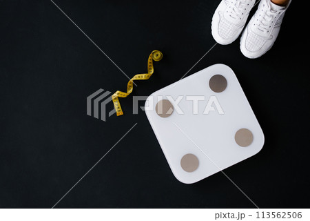 Flat lay scales, trainers and tape measure. Weight control concept 113562506