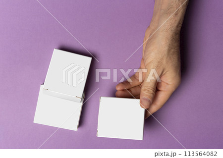 Male hand holding a pills box in front of purple background mock-up series Male hand holding a pills box in front of purple background mock-up series 113564082