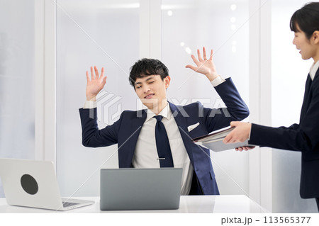 仕事量にお手上げをするビジネスマン 仕事量にお手上げをするビジネスマン 113565377