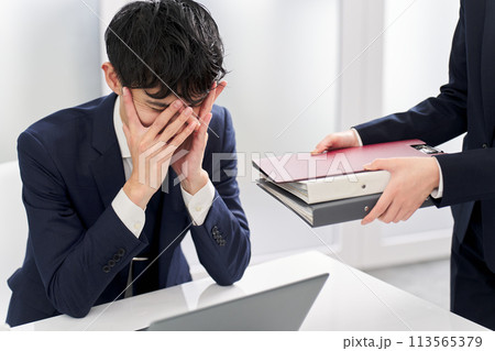 仕事量に塞ぎ込むビジネスマン 113565379