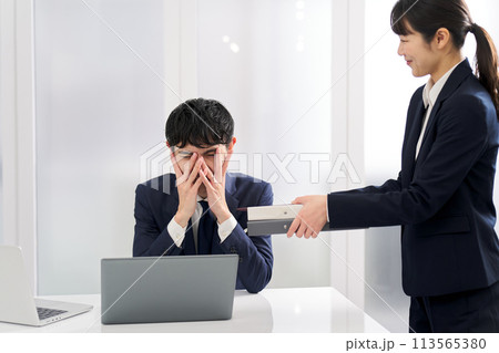 仕事量に塞ぎ込むビジネスマン 仕事量に塞ぎ込むビジネスマン 113565380