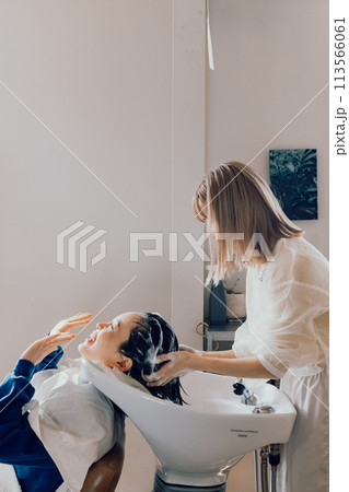 美容室でシャンプーをしてもらう若い女性 113566061